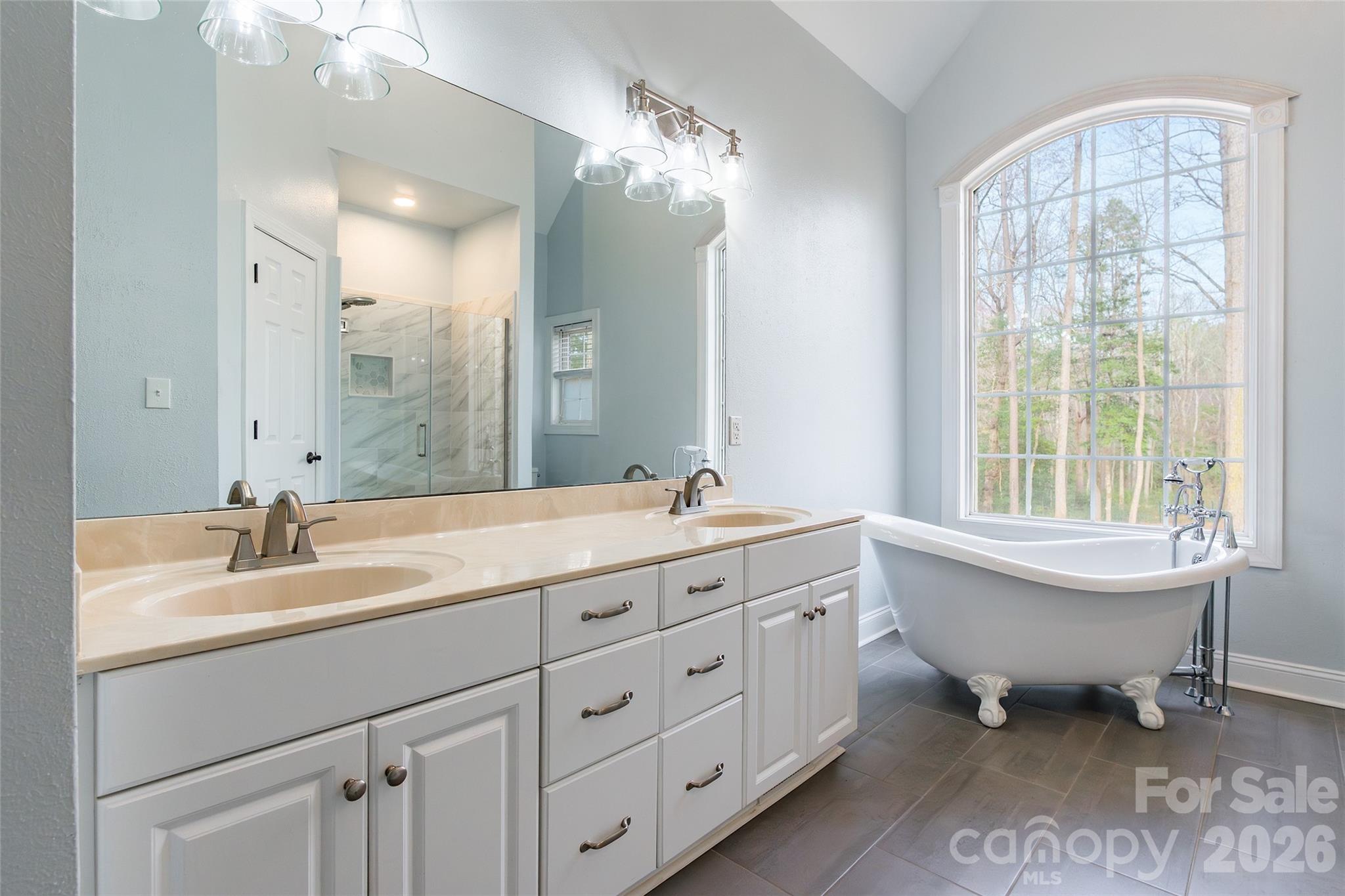 321 Forbes Court Clover, SC 29710 - Photo 14 of 31 a spacious bathroom with double vanity sink a mirror a lamp a window and a bathtub