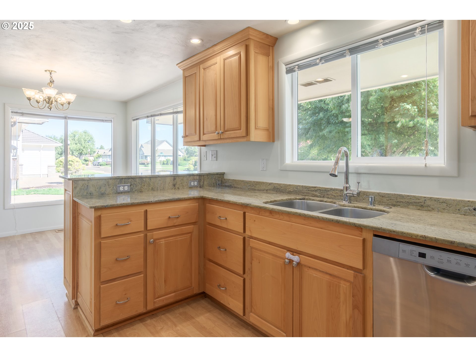 708 Blackstone Street Springfield, OR 97477 - Photo 9 of 45 a kitchen with granite countertop wooden cabinets a sink and a window