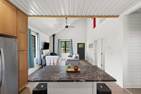 a view of living room with stainless steel appliances granite countertop furniture and a fireplace