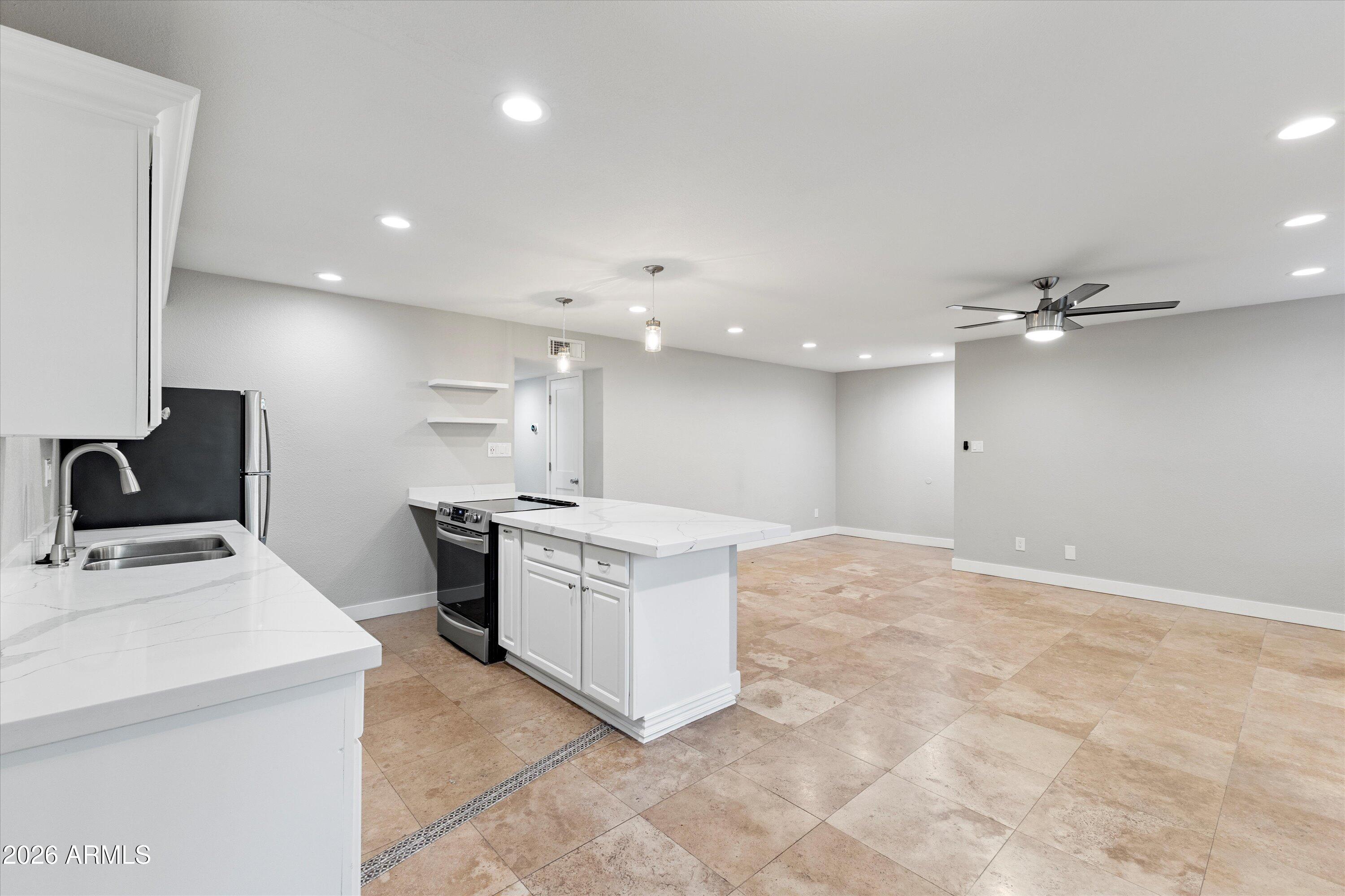 5525 East Thomas Road, Unit L1 Phoenix, AZ 85018 - Photo 15 of 33 a kitchen with kitchen island a sink stainless steel appliances and white cabinets