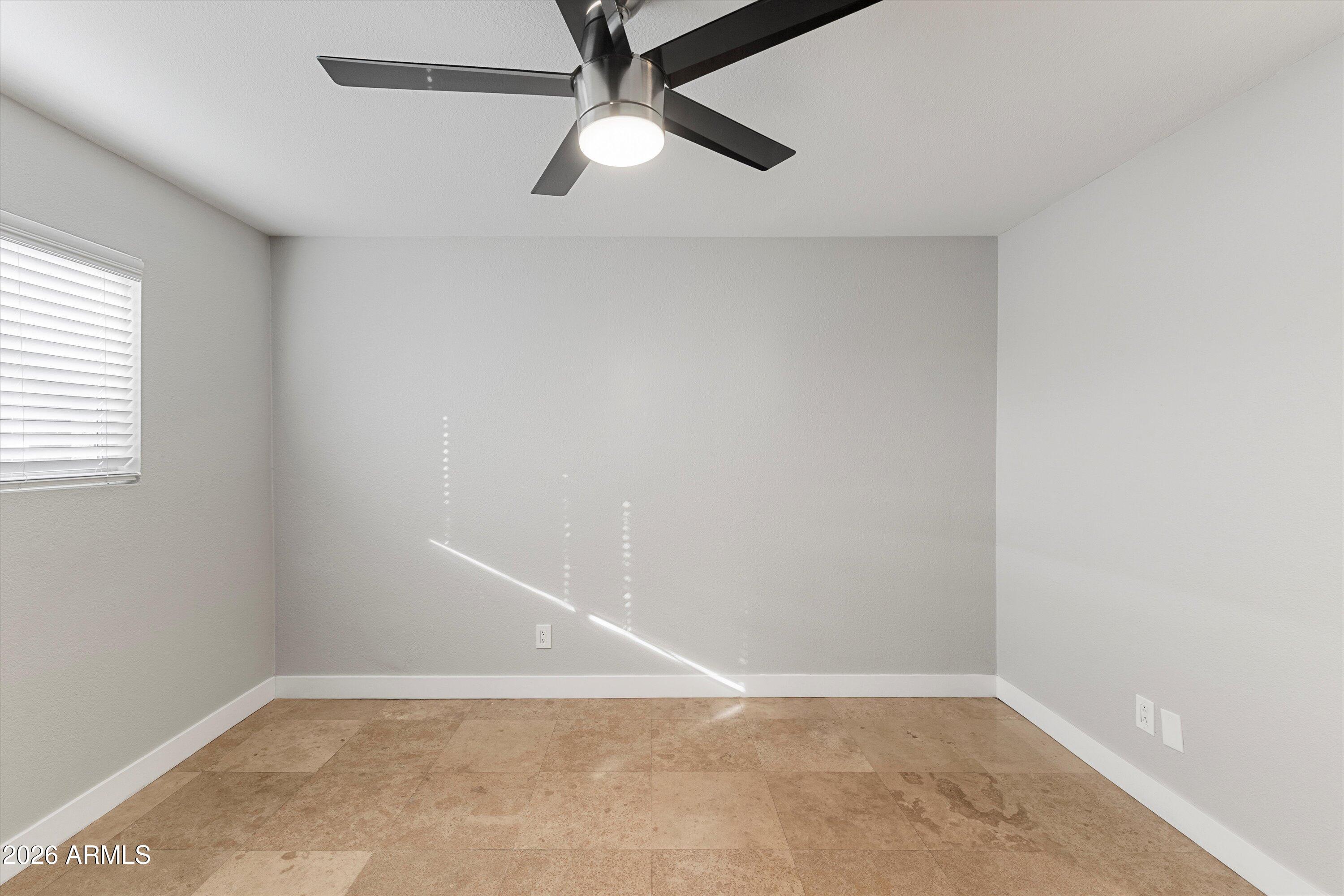5525 East Thomas Road, Unit L1 Phoenix, AZ 85018 - Photo 19 of 33 an empty room with a window and a fan