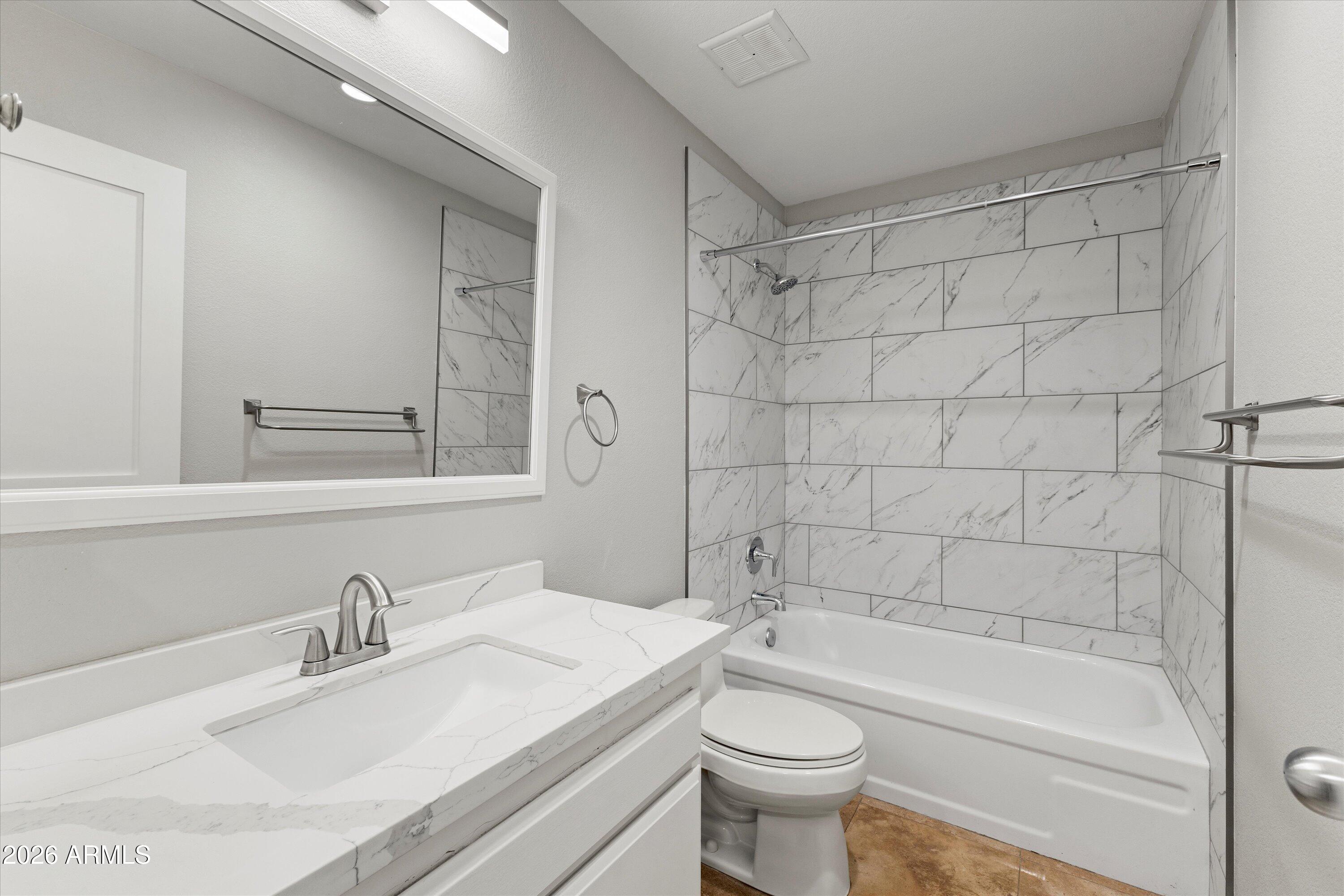 5525 East Thomas Road, Unit L1 Phoenix, AZ 85018 - Photo 20 of 33 a bathroom with a bathtub shower sink vanity mirror and toilet