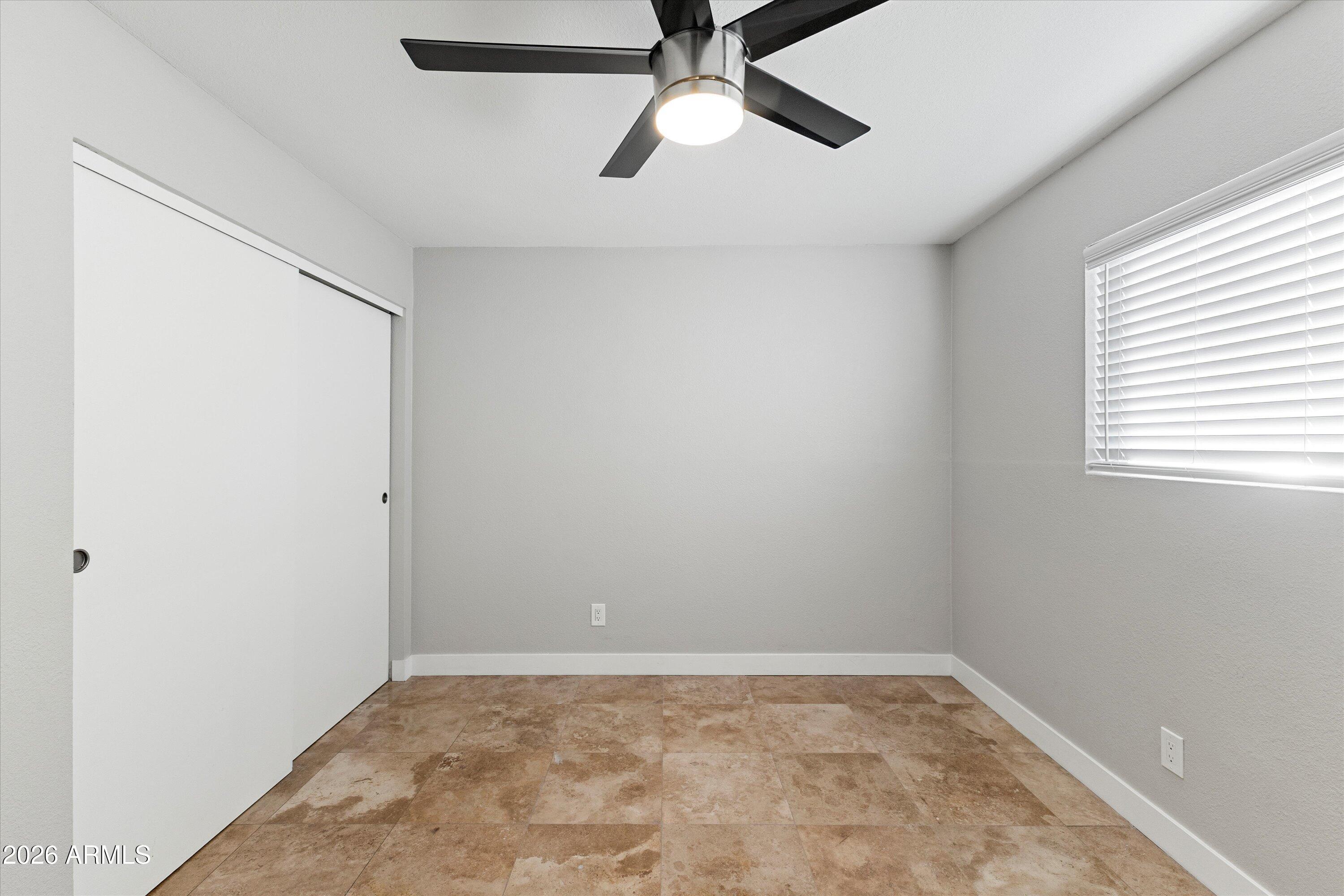 5525 East Thomas Road, Unit L1 Phoenix, AZ 85018 - Photo 24 of 33 an empty room with a window and a fan