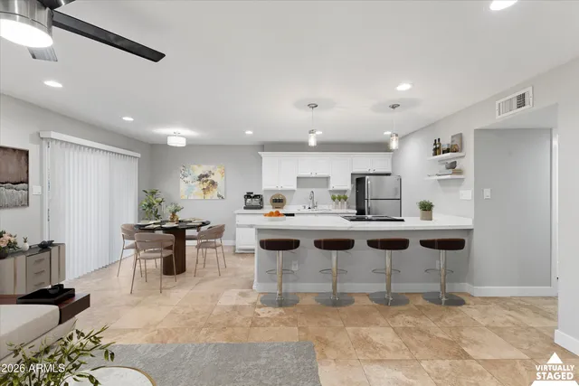 a view of a kitchen with kitchen island stainless steel appliances a table and chairs in it