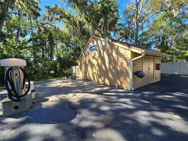 a view of a barn with a yard and large trees