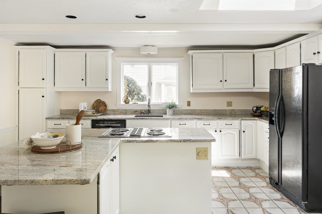 20 Stowell Road Winchester, MA 01890 - Photo 15 of 34 a kitchen with kitchen island granite countertop a sink appliances cabinets and a window