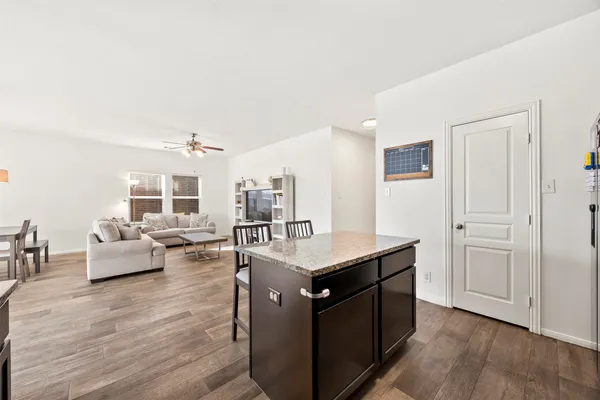 a kitchen with kitchen island stainless steel appliances a stove and wooden floor
