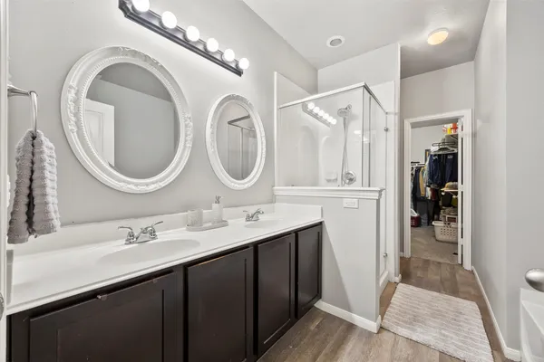 a bathroom with a double vanity sink mirror and shower