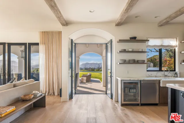 a view of a hallway with entryway and wooden floor