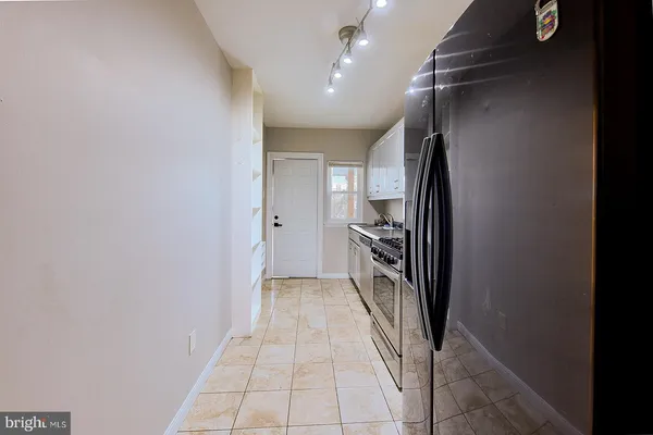 a view of a refrigerator in kitchen and empty room