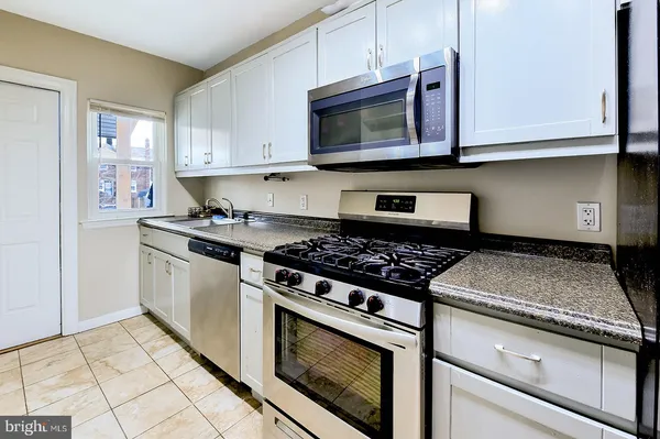 a kitchen with stainless steel appliances granite countertop a stove microwave and sink