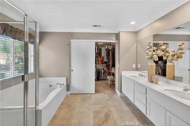 a bathroom with a sink toilet double vanity and shower