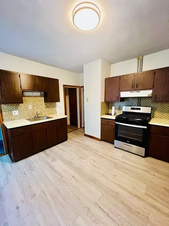 a kitchen with stainless steel appliances kitchen island granite countertop a stove a sink and a refrigerator