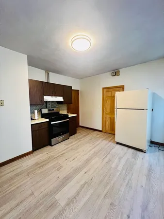 a kitchen with granite countertop a refrigerator and a stove top oven