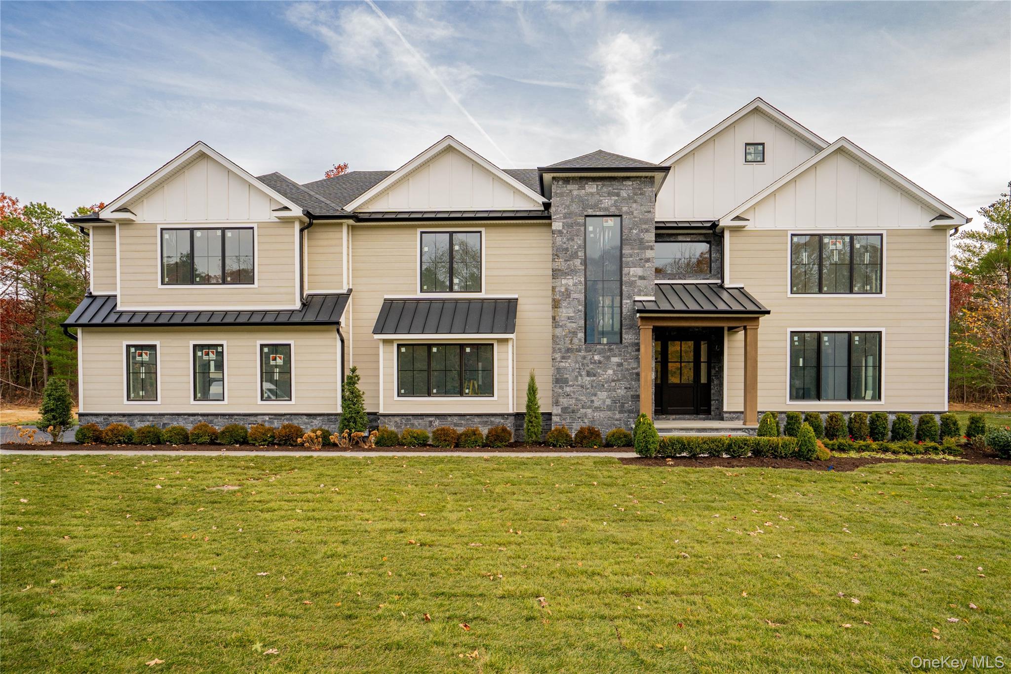 Lot 2-1003 Baldwin Path Dix Hills, NY 11746 - Photo 1 of 20 Modern inspired farmhouse with board and batten siding, a standing seam roof, a metal roof, a front lawn, and stone siding