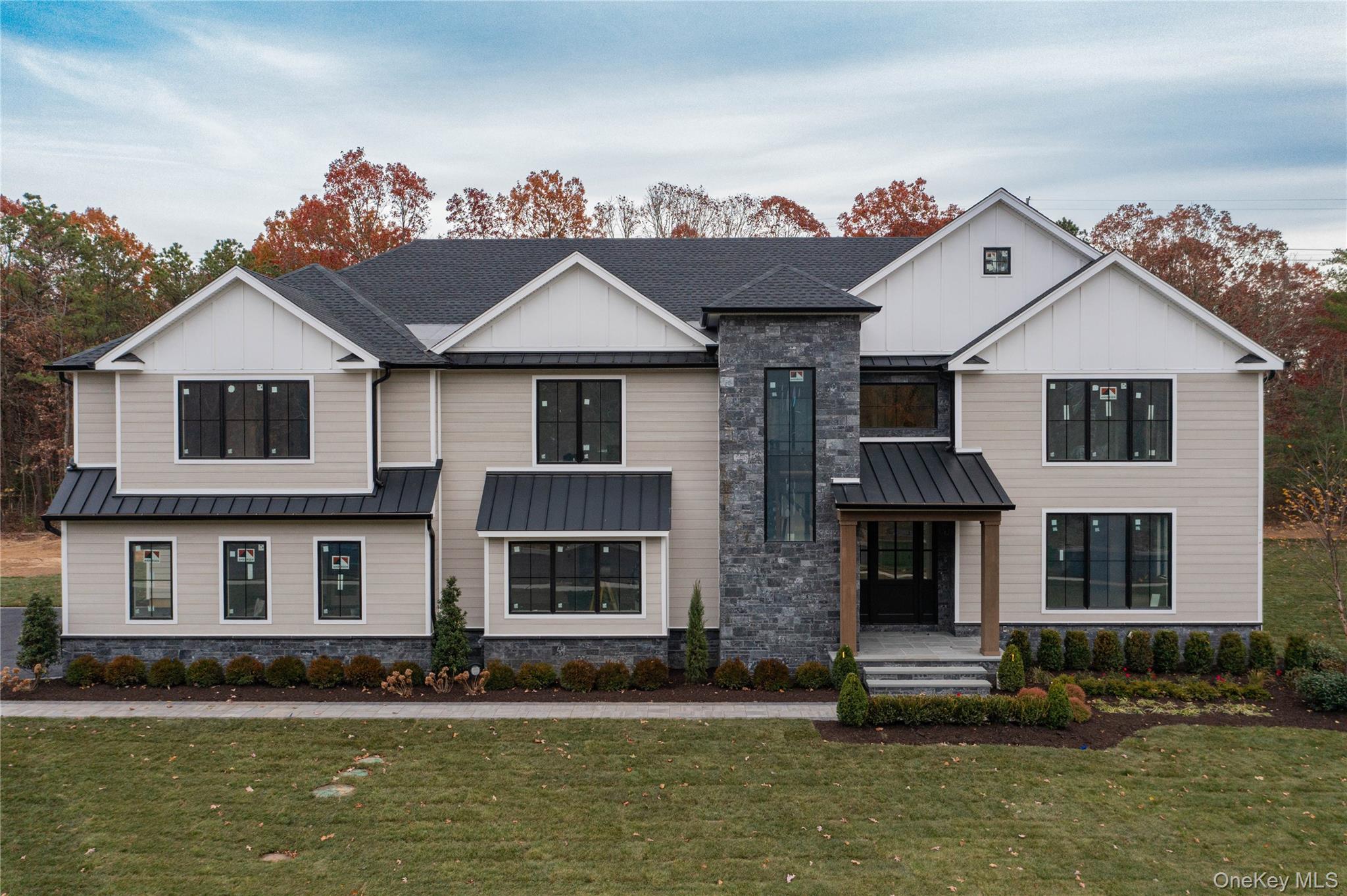 Lot 2-1003 Baldwin Path Dix Hills, NY 11746 - Photo 2 of 20 Modern farmhouse style home with board and batten siding, a front yard, roof with shingles, and stone siding