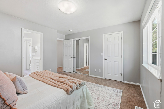 108 Penhurst Place Logan, UT 84341 - Photo 21 of 44 Carpeted bedroom featuring a large window, a paneled door, and a mirrored closet