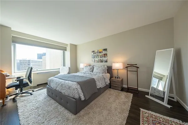 a bedroom with a bed and wooden floor