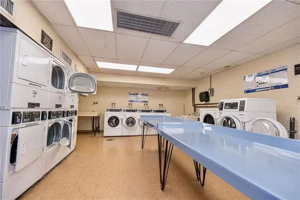 a kitchen with kitchen island a stove a sink a refrigerator cabinets and a dining table