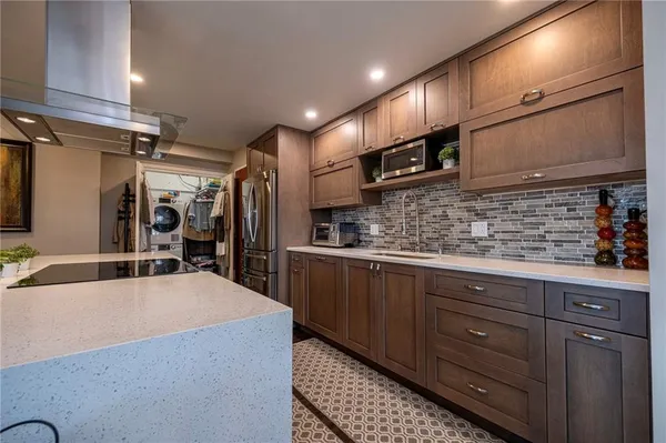 a kitchen with stainless steel appliances kitchen island granite countertop a sink and cabinets