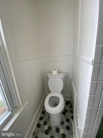 a white toilet sitting in a bathroom next to a sink