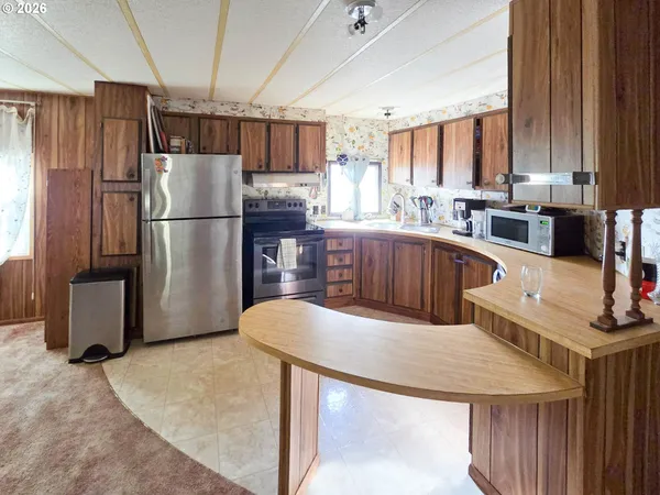 a kitchen with stainless steel appliances granite countertop a refrigerator a sink and a stove