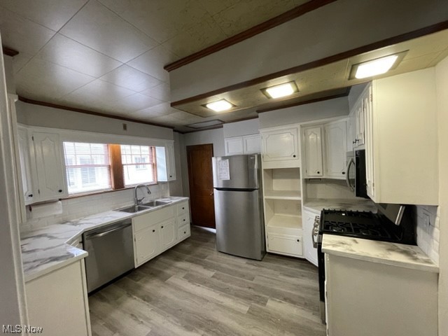 997 Berwin Street Akron, OH 44310 - Photo 17 of 34 Kitchen featuring stainless steel appliances, white cabinetry, light countertops, light hardwood flooring, and backsplash