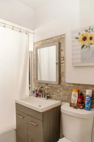 a bathroom with a sink toilet and a mirror