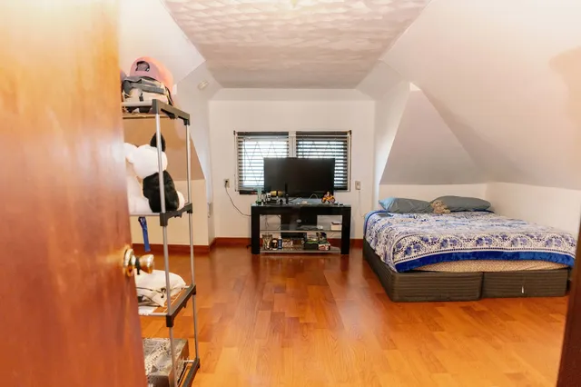 a bedroom with a bed and wooden floor