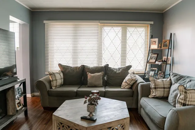 a living room with furniture a large window and a flat screen tv