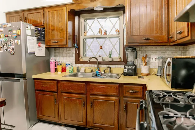 a kitchen with stainless steel appliances wooden cabinets and a stove top oven