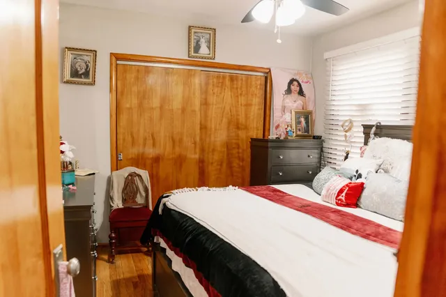 a bedroom with a bed dresser and a chandelier