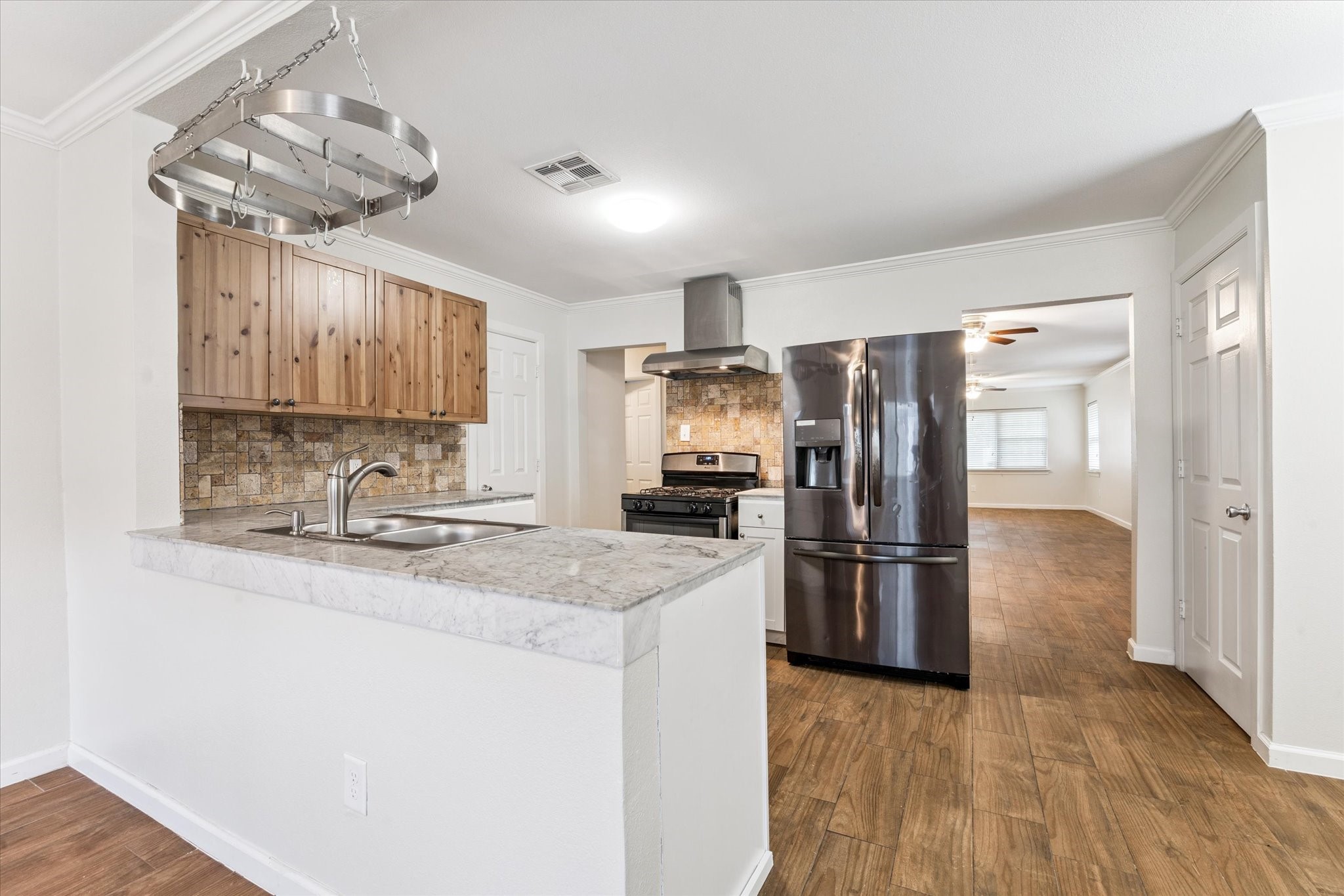 3810 Grennoch Lane Houston, TX 77025 - Photo 4 of 17 a kitchen with stainless steel appliances granite countertop a refrigerator a sink a stove a microwave and wooden floor