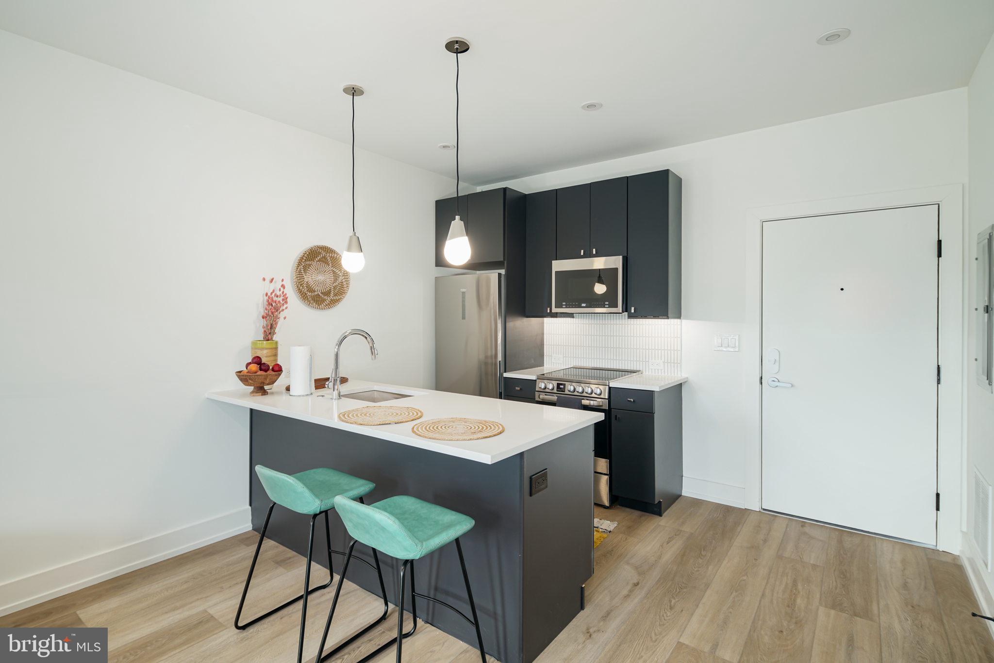 5013 Springfield Avenue, Unit 301 Philadelphia, PA 19143 - Photo 5 of 17 a kitchen with a table and chairs in it