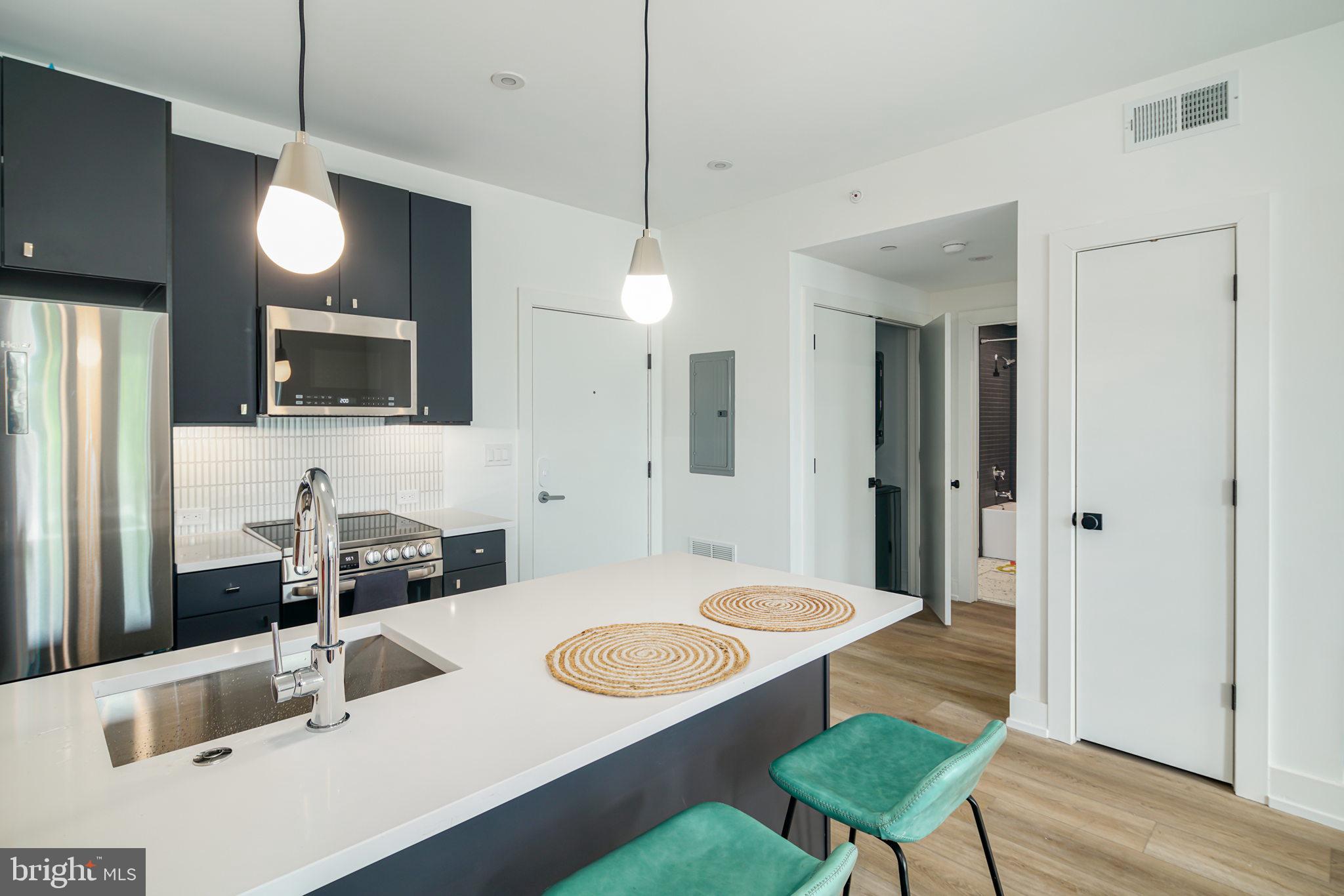 5013 Springfield Avenue, Unit 301 Philadelphia, PA 19143 - Photo 9 of 17 a kitchen with a table chairs and a chandelier