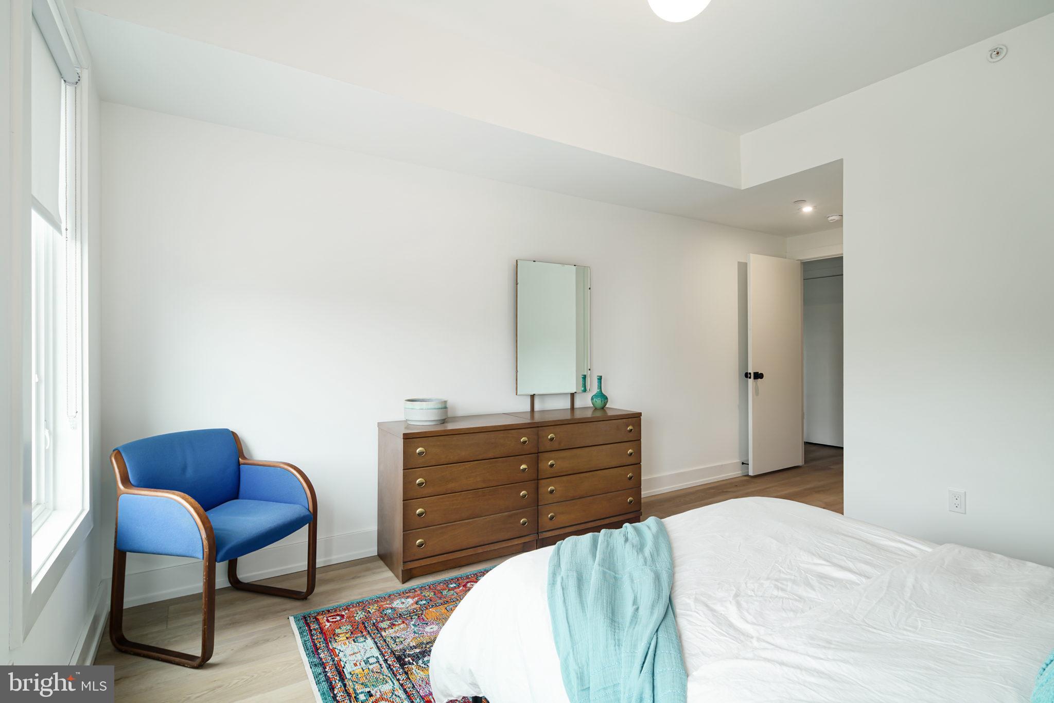 5013 Springfield Avenue, Unit 301 Philadelphia, PA 19143 - Photo 10 of 17 a bedroom with a bed and a chair