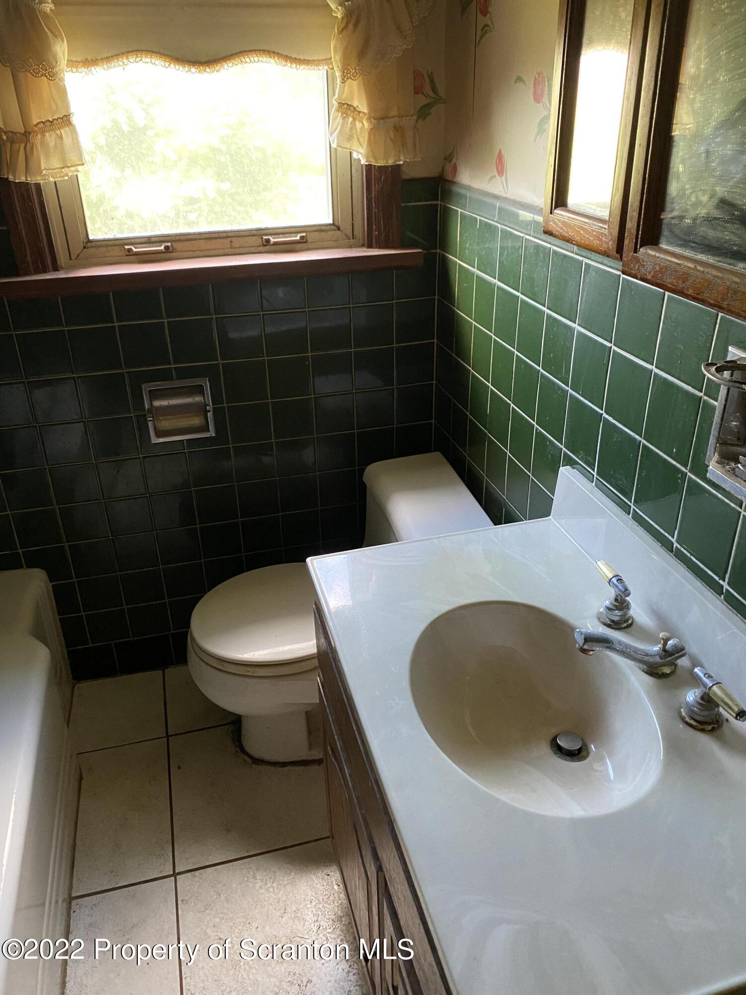 2008 South Webster Avenue Scranton, PA 18505 - Photo 22 of 37 a bathroom with a sink a toilet and a mirror