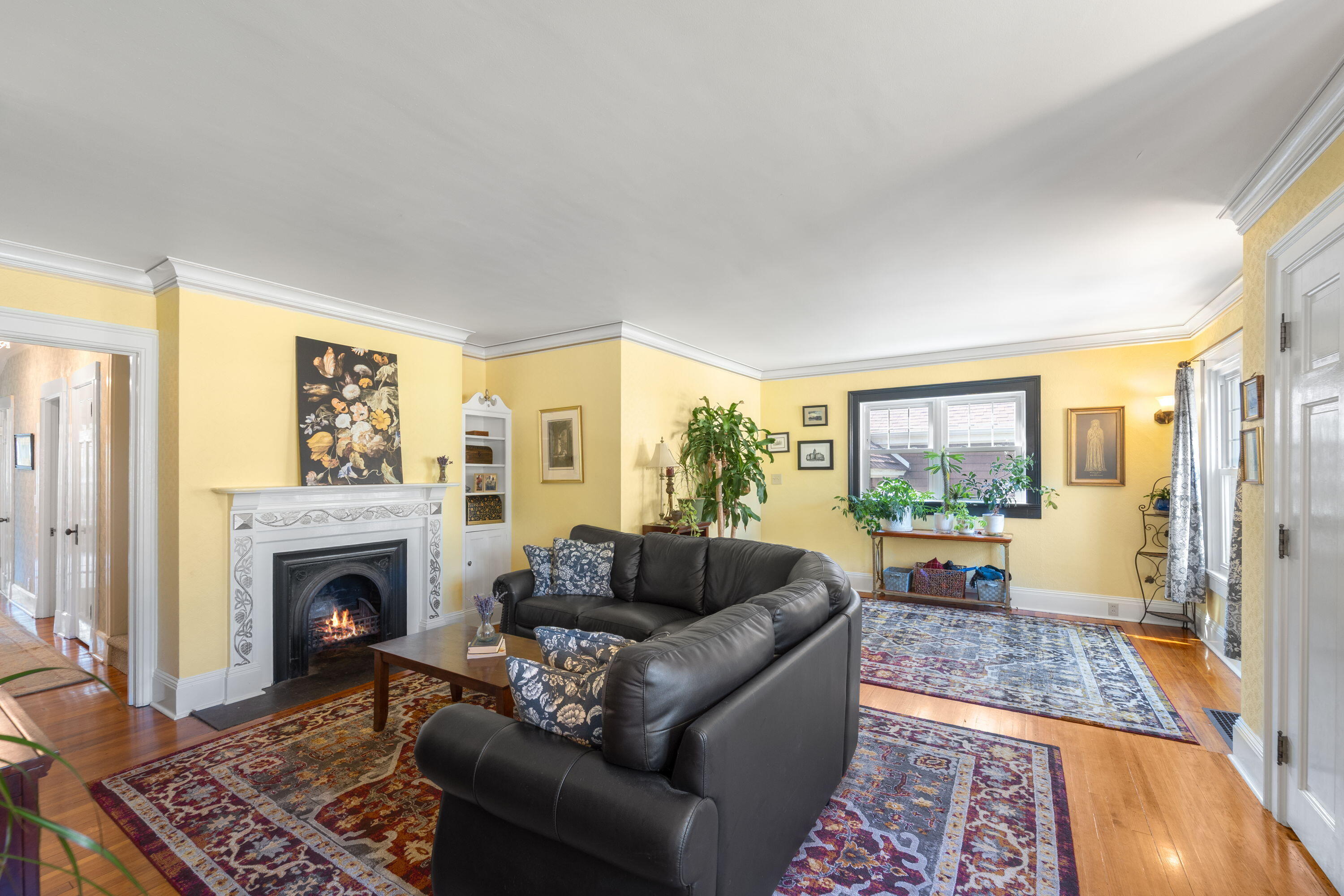 1213 College Avenue Racine, WI 53403 - Photo 4 of 31 Elegant living room blends historic charm with modern comfort — gleaming hardwood floors, sun-filled windows, and timeless architectural details just blocks from Lake Michigan.