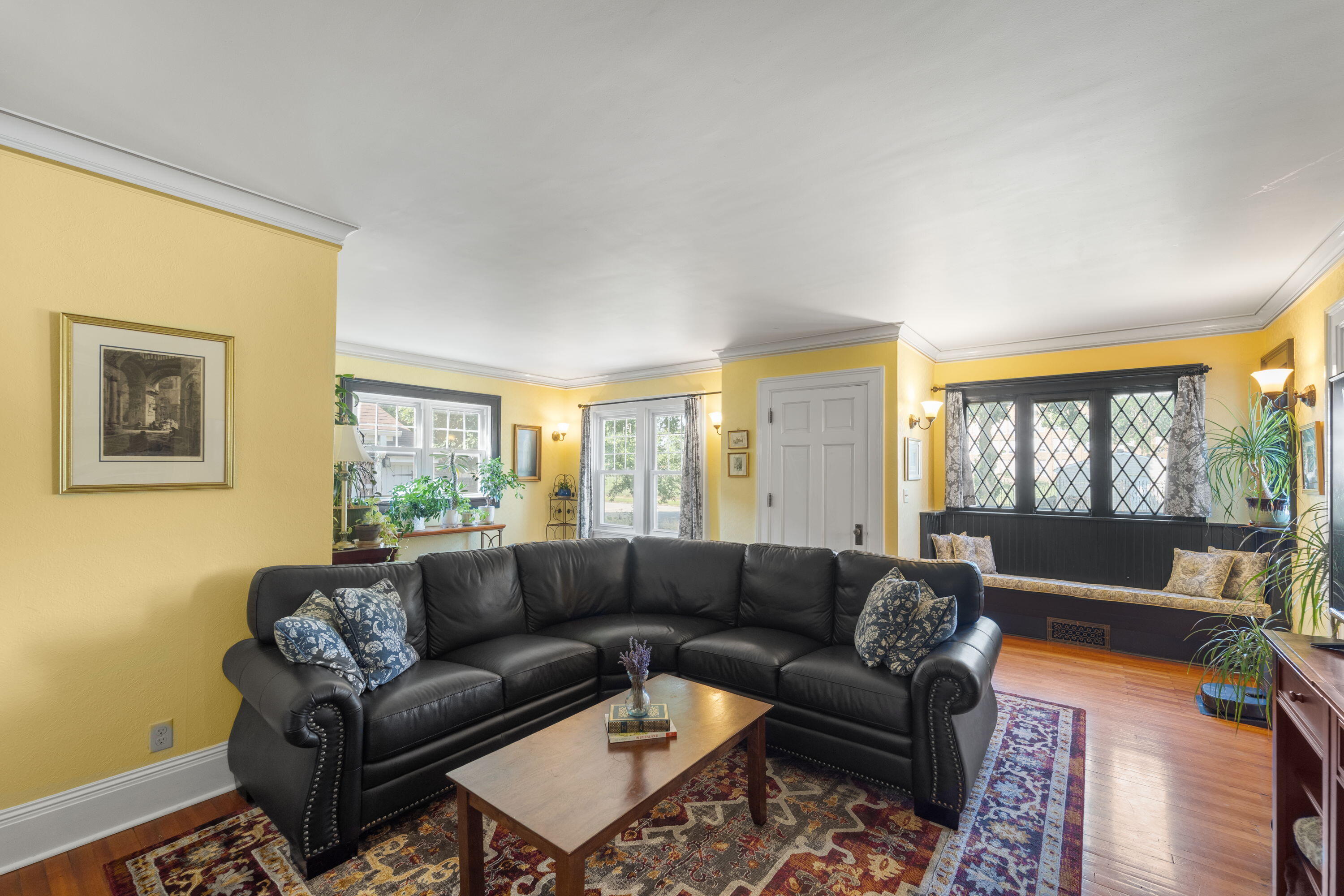 1213 College Avenue Racine, WI 53403 - Photo 5 of 31 Inviting living room with gleaming hardwood floors and unique built in bench
