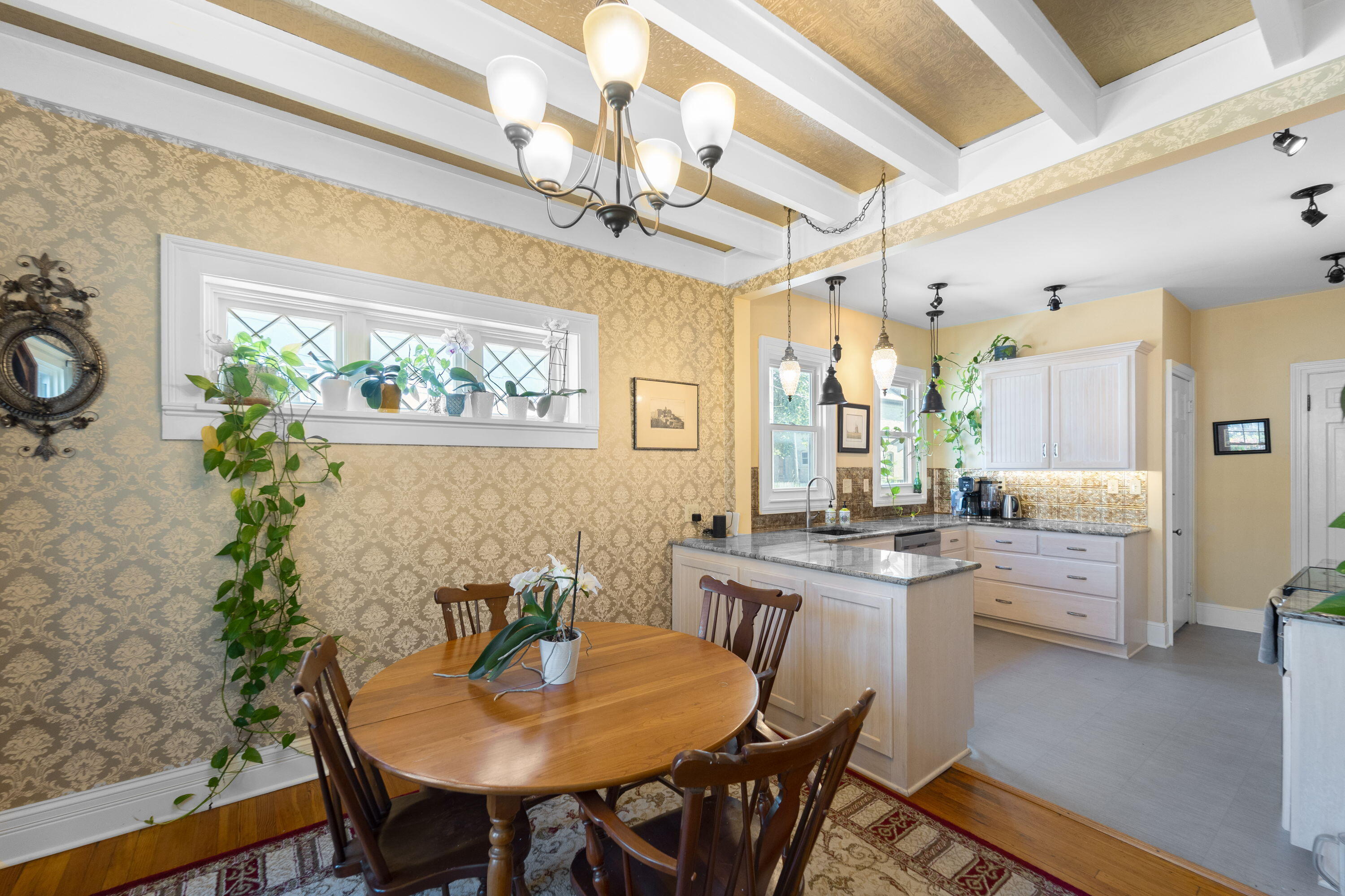 1213 College Avenue Racine, WI 53403 - Photo 6 of 31 Uncompromised historic charm flows into the dining room, where original decorative windows frame the space and an open layout connects seamlessly to the kitchen.