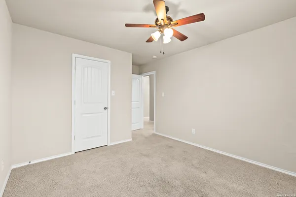 an empty room with a chandelier fan and a ceiling fan