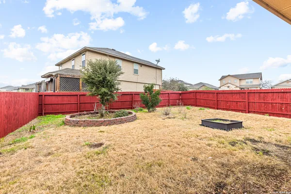 a view of backyard with wooden fence