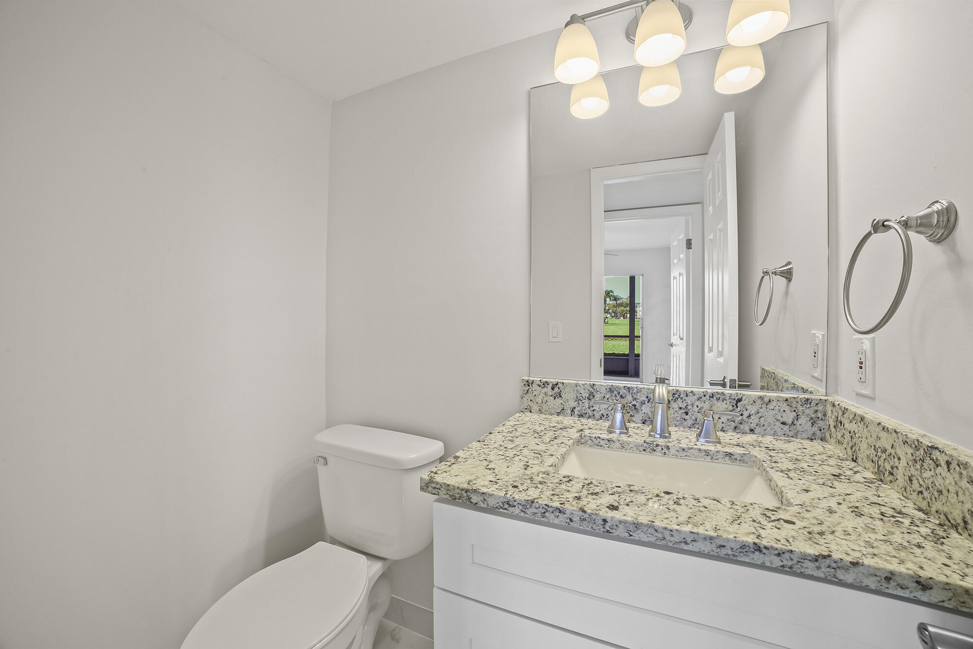 182 Preston F, Unit 182 Boca Raton, FL 33434 - Photo 8 of 17 a bathroom with a granite countertop sink and a mirror