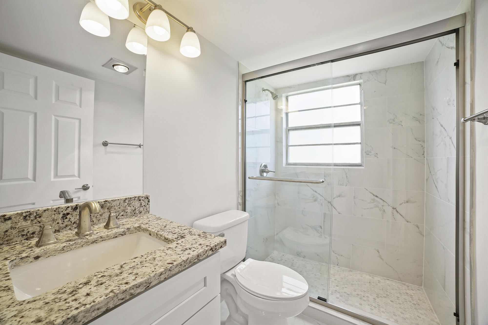 182 Preston F, Unit 182 Boca Raton, FL 33434 - Photo 9 of 17 a bathroom with a granite countertop sink a toilet and shower