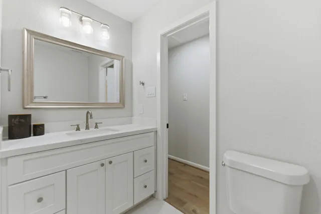 a bathroom with a toilet sink and mirror
