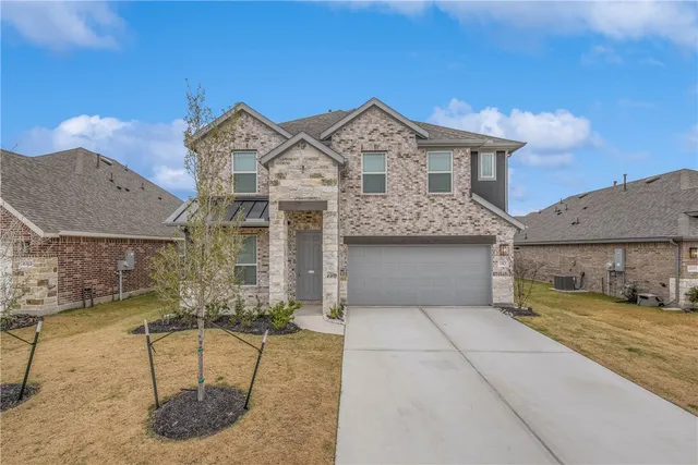 a front view of a house with a garden and yard