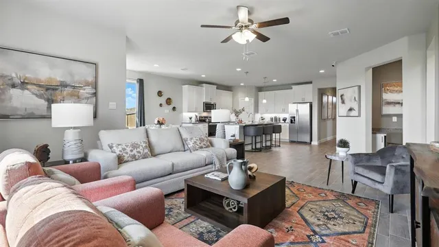 a living room with furniture a flat screen tv and a window