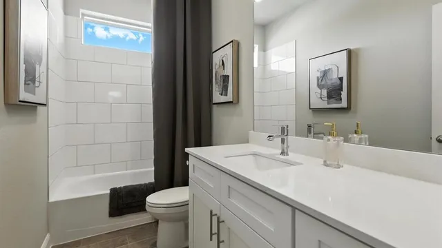 a bedroom with a bed painting on wall and a large window