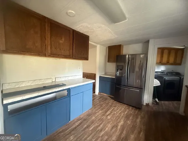 a kitchen with a refrigerator sink and wooden cabinets