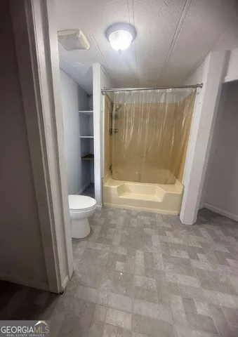 a bathroom with a toilet and a shower
